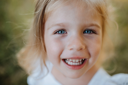A close-up portrait of small girl in sunny summer nature.の写真素材