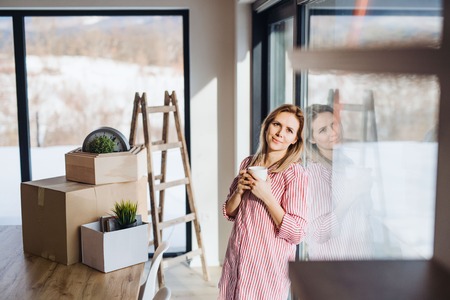 A young woman moving in new home, drinking coffee.の写真素材