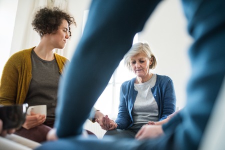 Men and women sitting in a circle during group therapy, supporting each other.の写真素材