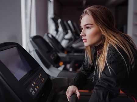 A side view of young girl or woman doing cardio workout in a gym.の写真素材