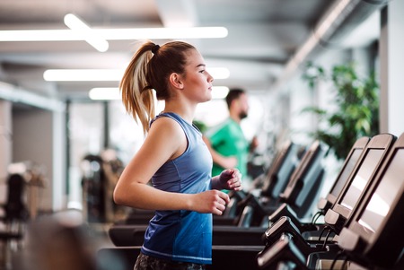 A portrait of young girl or woman doing cardio workout in a gym.の写真素材