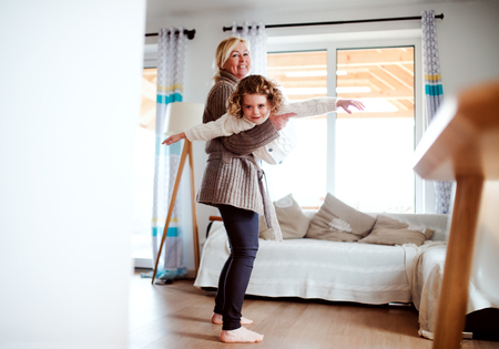 A portrait of small girl with grandmother having fun at home.の写真素材
