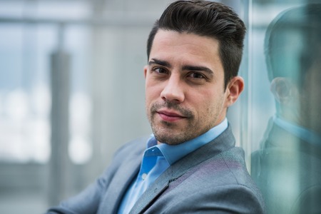 A portrait of young businessman indoors in an office.