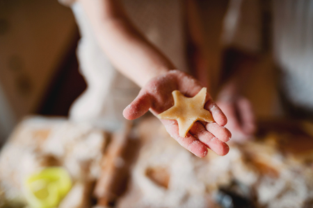 A midsection of small toddler boy making cakes at home.の写真素材