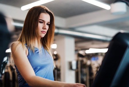A portrait of young girl or woman doing cardio workout in a gym.の写真素材
