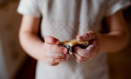 A midsection of small toddler boy making cakes at home.の写真素材