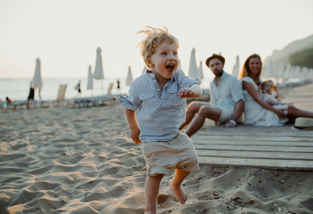 Young family with toddler children having fun on beach on summer holiday.の写真素材