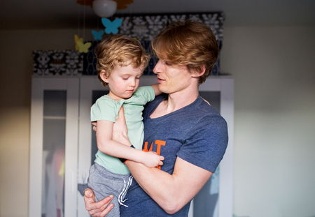 A happy father with a toddler son at home.の写真素材