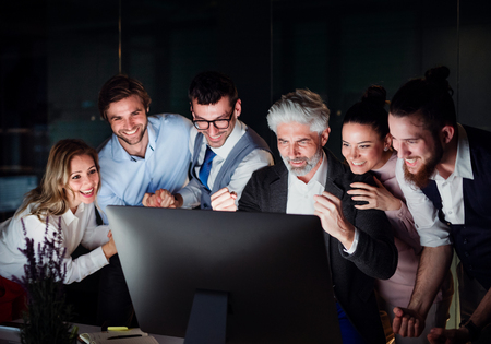 A group of business people with computer in an office, expressing excitement.の写真素材