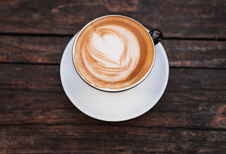 A cup of coffee on a dark wooden table.の写真素材