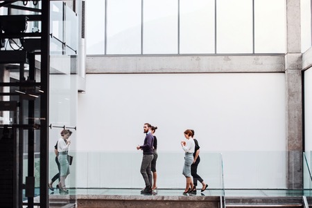 Group of young businesspeople at work, walking in the building.の写真素材