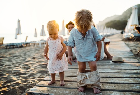 Young family with toddler children having fun on beach on summer holiday.の写真素材