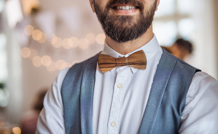 Midsection of man standing indoors in a room set for a party.の写真素材