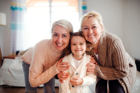 A portrait of small girl with mother and grandmother at home.の写真素材