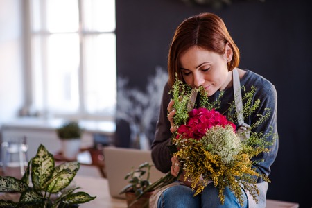 Young creative woman in a flower shop. A startup of florist business.の写真素材