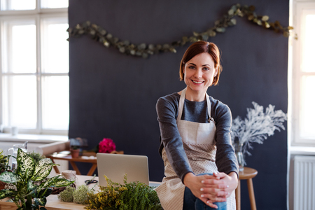 Young creative woman in a flower shop. A startup of florist business.の写真素材