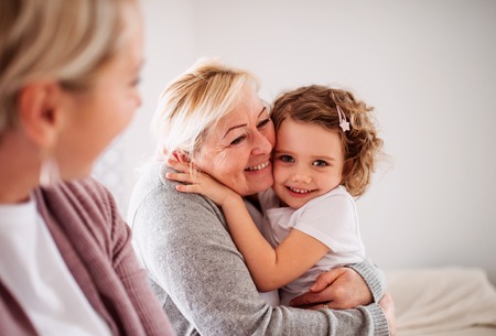 A portrait of small girl with mother and grandmother at home.の写真素材