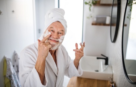 A senior man doing morning routine in bathroom indoors at home.の写真素材