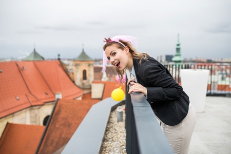 A woman with princess headband on party outdoors on roof terrace in city.の写真素材
