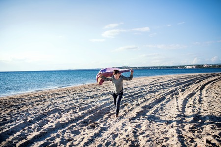 A small boy playing outdoors on sand beach.の写真素材