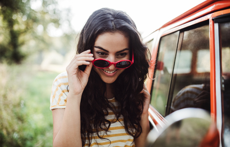 A girl looking in mirror on a roadtrip through countryside.の写真素材