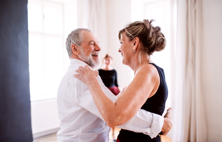 Senior couple attending dancing class in community center.の写真素材