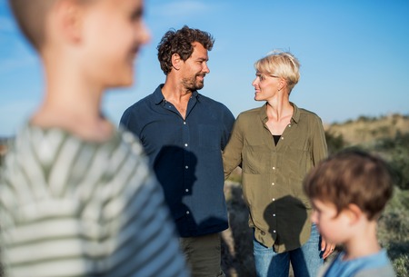 Young family with two small children standing outdoors in nature.の写真素材