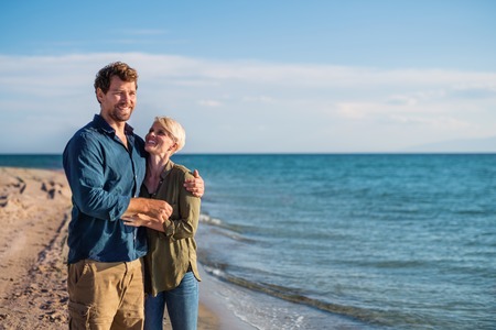 Young couple standing outdoors on beach, talking. Copy space.の写真素材
