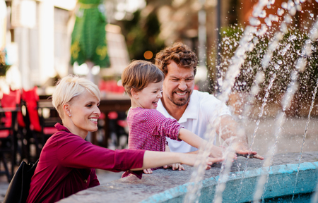 Parents with two small daugther having fun outdoors in town.の写真素材