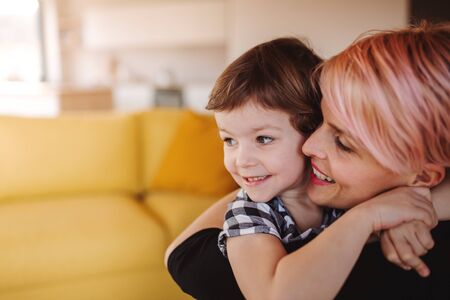 A close-up portrait of young woman with small daughter at home. Copy space.の写真素材