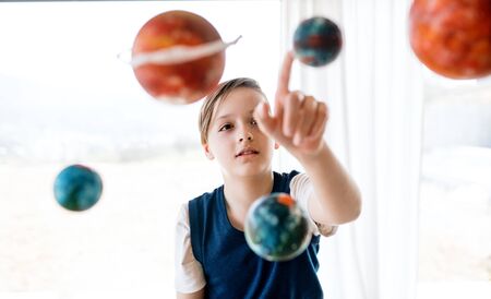 A small boy with model of solar system indoors.の写真素材