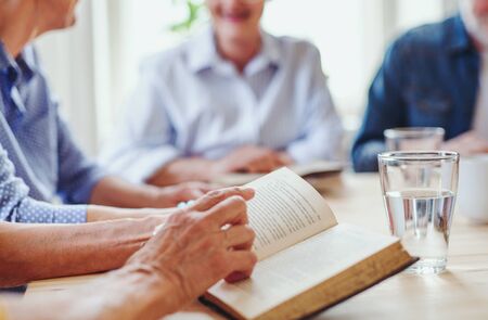 Midsection of senior people in bible reading group in community center club.の写真素材