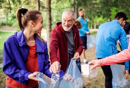 Group of fit people picking up litter in nature, a plogging concept.の写真素材