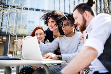 Young businesspeople with laptop in courtyard, start-up concept.の写真素材