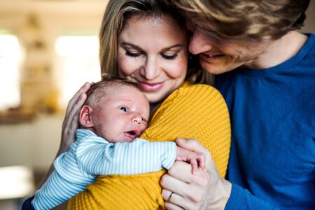 Beautiful young parents with a newborn baby at home.