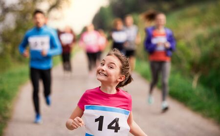 Large group of multi generation people running a race competition in nature.の写真素材