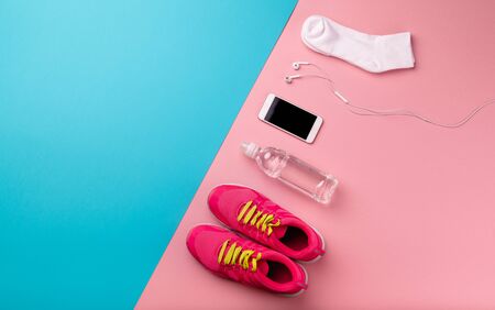 A studio shot of running shoes and smartphone on color background. Flat lay.の写真素材