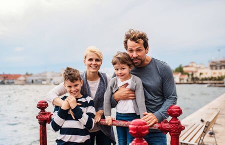 Portrait of young family with two small children outdoors on beach.の写真素材