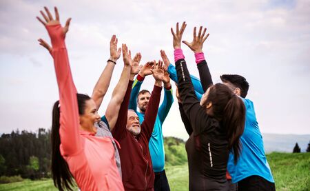 Large group of fit and active people resting after doing exercise in nature.の写真素材