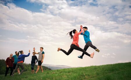 Large group of fit and active people jumping after doing exercise in nature.の写真素材