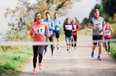 Large group of multi generation people running a race competition in nature.の写真素材