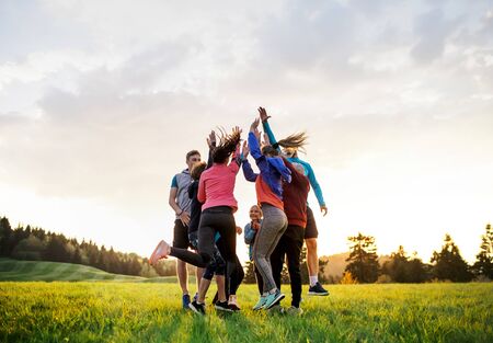 Large group of fit and active people jumping after doing exercise in nature.の写真素材