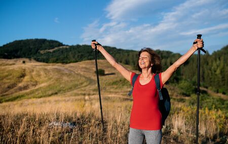 Senior woman tourist with backpack hiking in nature, resting.の写真素材