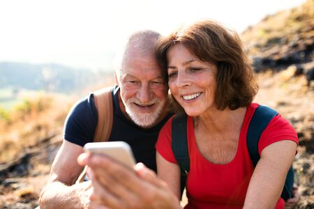 Senior tourist couple hikers in nature, taking selfie.の写真素材