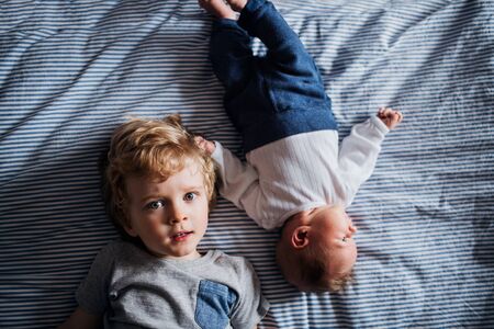 A top view of small boy with a newborn baby brother at home.の写真素材