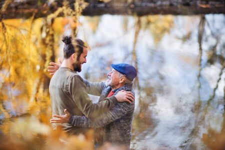 High angle view of senior father and his son standing in nature, talking.の写真素材