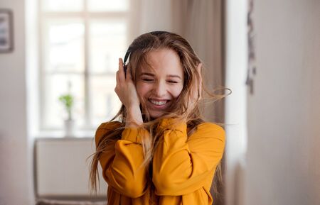 A young female student with headphones having fun.の写真素材