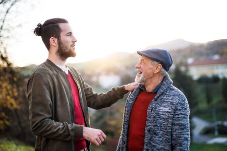Senior father and his son on walk in nature, talking.の写真素材
