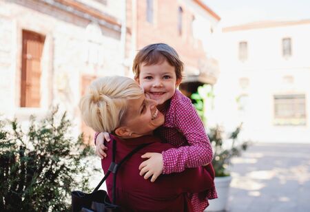Mother with small daughter standing outdoors in mediterranean town.の写真素材