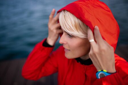 Portrait of young sportswoman standing outdoors on beach.